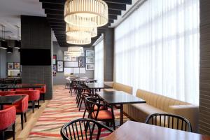 多瓦尔蒙特利尔机场万豪酒店的餐厅设有桌椅和大窗户。