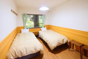 山中湖村Village Kagetsuen的带窗户的客房内的两张床