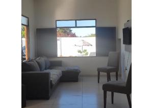 若昂佩索阿Hostel Summer Praia do Sol的客厅配有沙发、椅子和遮阳伞