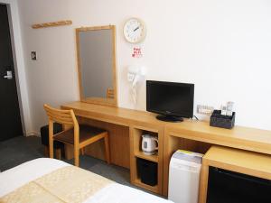 Iidamachiビジネスホテル 山手INN的客房设有一张带电视和镜子的书桌