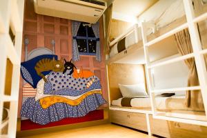 清迈Chiangmai Midpoint Activity Hostel的一间设有双层床的客房,床上挂着一只猫的画作