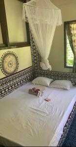 Naviti IslandWai Makare Homestay的一间卧室配有一张带天蓬的白色床
