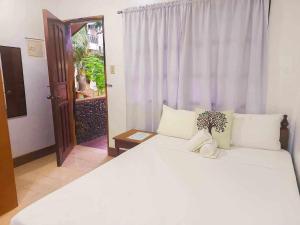 爱妮岛Jurias Garden Hotel的卧室设有一张白色大床和一扇窗户。