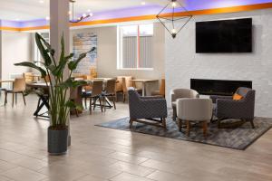 WillistonLa Quinta Inn & Suites by Wyndham Williston Burlington的大堂设有桌椅和壁炉。