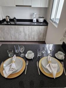 利马Barranco Aparment Luxury的一张桌子,上面有两盘,玻璃杯和餐巾
