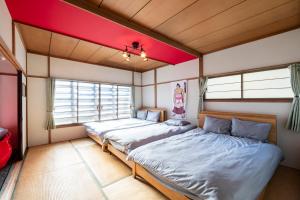 小樽HATSUNE的红色天花板的客房内的两张床