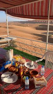 Al RakaRoyal desert camp的海滩上的野餐桌和食物