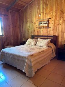 里坎雷Cabaña Flor de Lican的一间卧室配有一张木墙床