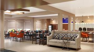 雷丁雷丁华美达有限酒店的一间带沙发和桌椅的餐厅
