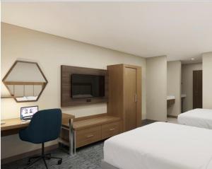 雷丁雷丁华美达有限酒店的酒店客房设有两张床、一张桌子和一台电视。