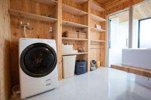 热海&y,atami - Vacation STAY 36193v的木墙房间内的洗衣机和烘干机
