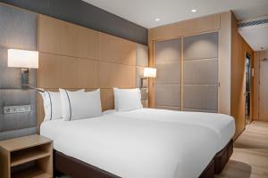 巴塞罗那维多利亚套房万豪AC酒店的一张大白色的床,位于酒店客房内