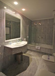 费罗尔Hotel Almirante的一间带水槽、浴缸和卫生间的浴室
