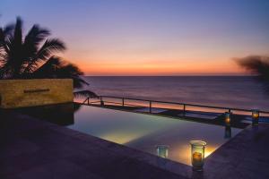 曼克拉德克套房休息室&Spa酒店的日落时分享有海洋美景的游泳池