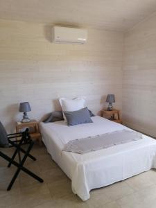 布拉伊NIAOULI LODGE的一间卧室配有一张带两盏灯的大型白色床。