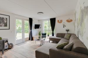 EwijkHet Huys Ewijk mooi luxe en een laadpaal的带沙发和电视的客厅