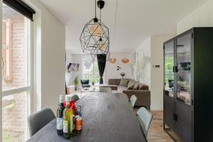 EwijkHet Huys Ewijk mooi luxe en een laadpaal的用餐室和带桌子的客厅