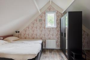 EwijkHet Huys Ewijk mooi luxe en een laadpaal的阁楼卧室设有两张床和窗户。