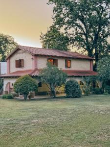 拉斯罗萨斯El Sosiego的粉红色和白色的房子,有大院子
