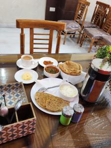 新德里Airport Hotel Claytone的餐桌上放有食物和面包的盘子