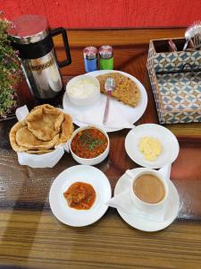 新德里Airport Hotel Claytone的餐桌,盘子上放着食物和碗