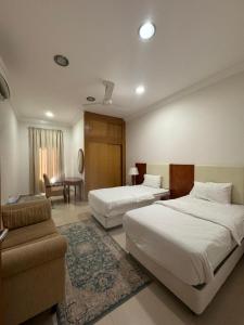 塞拉莱بيت السلطانة للأجنحة الفندقية的酒店客房,设有两张床和一张沙发