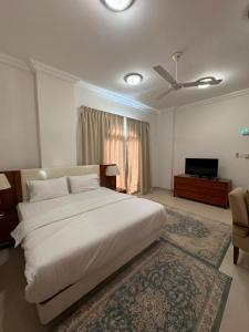 塞拉莱بيت السلطانة للأجنحة الفندقية的卧室配有一张白色大床和电视。
