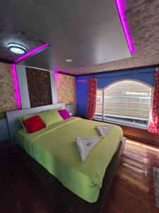 阿勒皮Beach Paradise Day Cruise Houseboat - VACCINATED STAFF的一间卧室配有一张带紫色灯的大型绿床