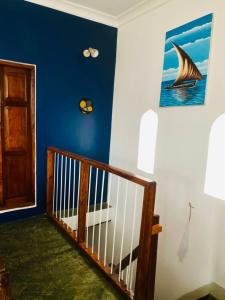 Stone TownSeafarers Loft的一间设有蓝色墙壁和帆船绘画的楼梯的房间
