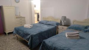 特鲁希略斯多诺拉斯昆特纳斯旅舍的一间卧室配有两张床、一个梳妆台和镜子
