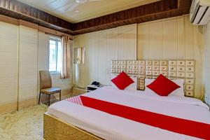 加尔各答Hotel Royal Inn的一间卧室配有一张带红色枕头的大床