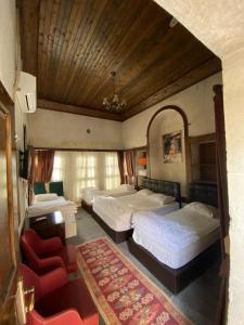 尚勒乌尔法HANIMAĞABUTİK OTEL的一间卧室配有两张床和红色椅子