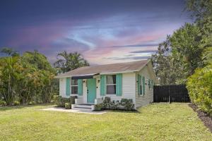 西棕榈滩Palm Wave Says - 5 min to Best Locations的院子里的绿色和白色小房子