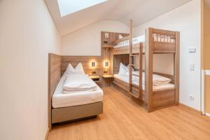 慕尼黑WESTSIDE Hotel的客房设有两张双层床和一张书桌。