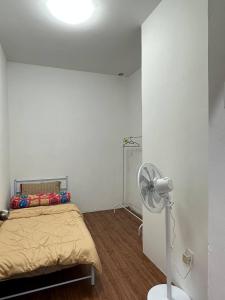 Yong PengAmir Homestay的白色的客房配有床和风扇