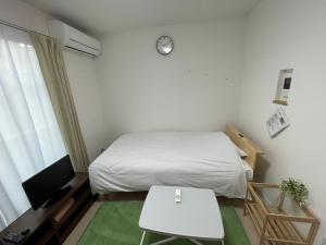 东京One Point Five的小房间设有床、桌子和电视