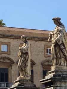 巴勒莫La Loggia dei Re的两座建筑前方的雕像