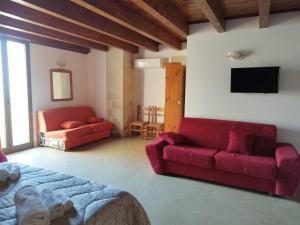 圣凯撒利亚温泉特拉瑟林纳酒店的客厅配有红色沙发和电视
