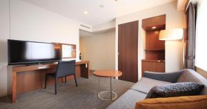 东京东京芝里士满酒店的酒店客房设有一张沙发和一张带电视的书桌。
