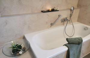 Schöne, helle, ruhige Wohnung und Wellness Sauna的浴室配有带蜡烛和毛巾的浴缸。