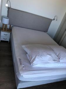 卡布尔Cabourg Face A La Mer的一张带床头板和灯的大型白色床