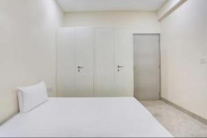 DahmiGAURA NITAI GUEST HOUSE的白色客房 - 带一张床和两个衣柜