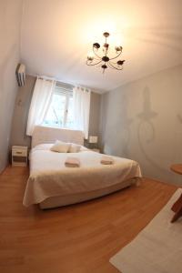 莫斯塔尔尼娜莫斯塔尔旅馆的一间卧室配有一张大床和一个吊灯。