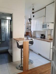 巴黎Chambre privée dans magnifique appartement calme的厨房配有白色橱柜和木制台面