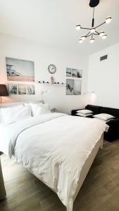 阿布扎比Canal view 3 bedroom holiday home with balcony的白色卧室设有一张大床和吊扇
