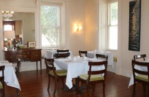 博福特Anchorage 1770的一间设有白色桌椅和窗户的用餐室