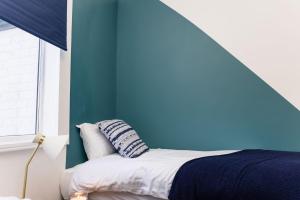 雷德卡Muriel Retreat - Central Location - Free Parking, Fast Wifi, SmartTV with Netflix by Yoko Property的一间卧室设有蓝色的墙壁和一张带枕头的床