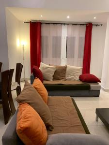 奥兰charmant appartement a oran gambetta pour famille的带沙发和红色窗帘的客厅