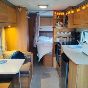 波特里Kintyre Caravan的一间小房间,设有厨房和一张床