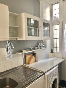 瓦灵福德Entire Cottage Style flat in heart of Wallingford的厨房配有白色橱柜、水槽和洗碗机。